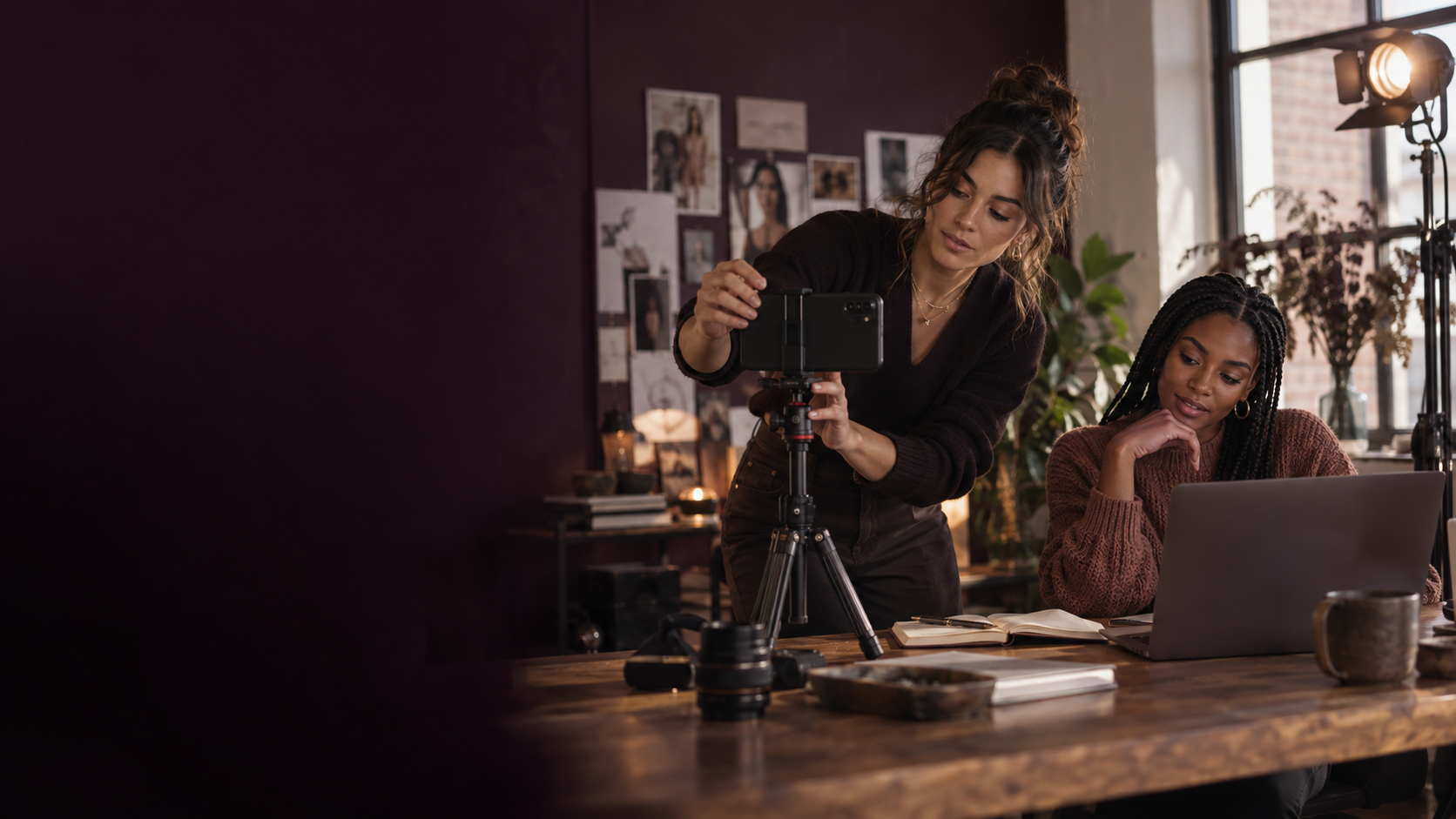 Two creators filming and reviewing content together in a warm studio